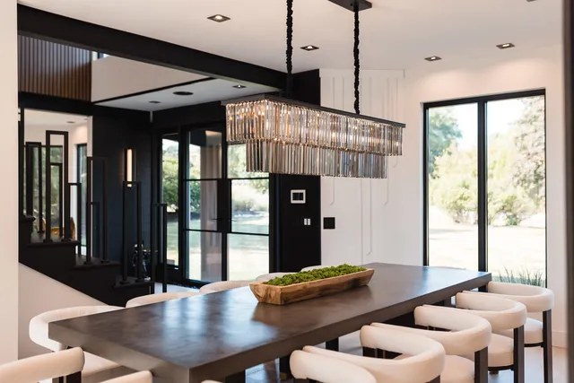 a dining room with furniture large windows and a chandelier