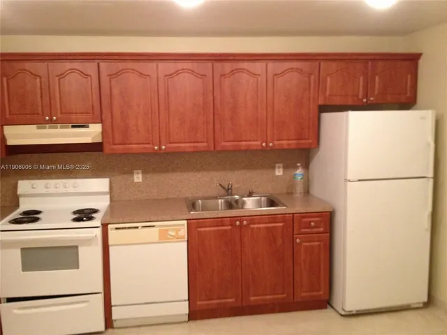 a kitchen with a refrigerator and a stove