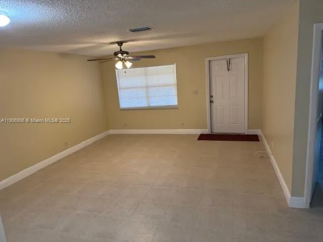 an empty room with windows and fan