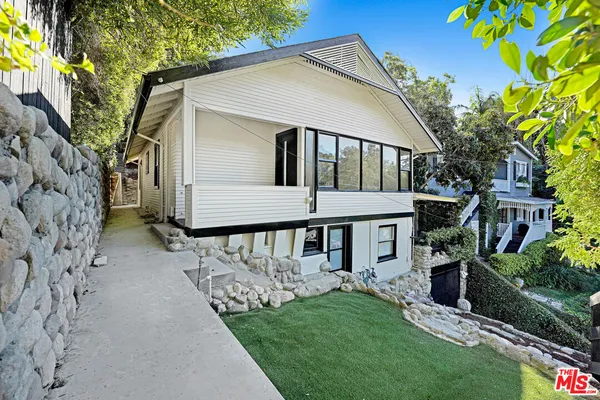 a front view of a house with a garden