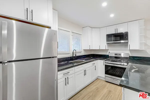 a kitchen with stainless steel appliances a refrigerator sink and microwave