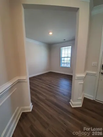 an empty room with wooden floor and window