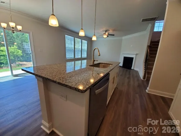 an open kitchen with granite countertop sink stove and refrigerator