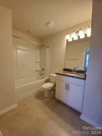 a bathroom with a granite countertop sink a toilet and a bathtub