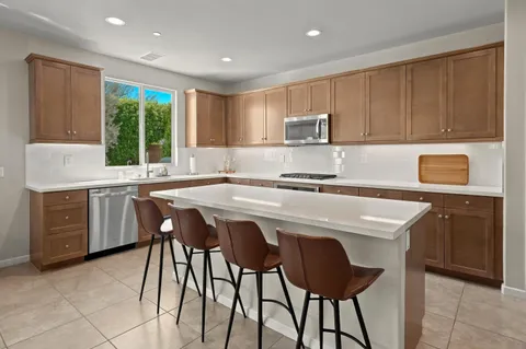 a large kitchen with kitchen island a large counter space and stainless steel appliances