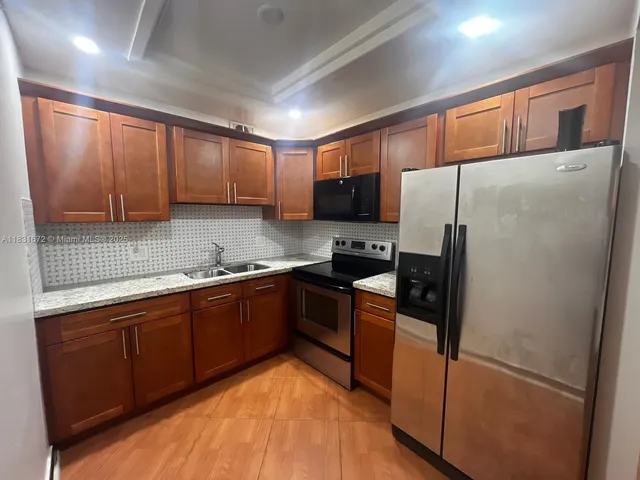 a kitchen with stainless steel appliances granite countertop a refrigerator stove and sink