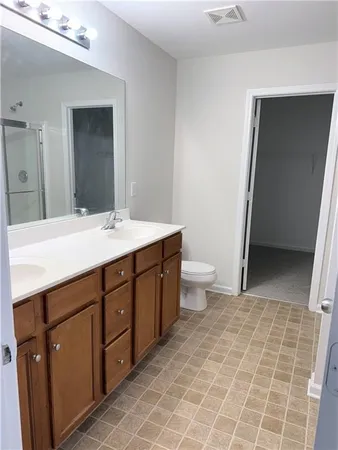 a bathroom with a glass door shower and a sink
