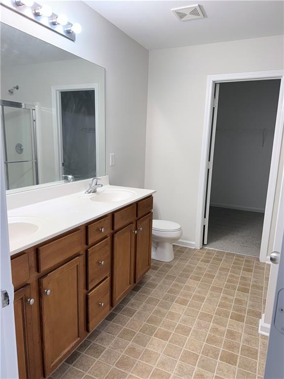 82 Kennedy Court Hiram, GA 30141 - Photo 20 of 26 a spacious bathroom with a double vanity sink toilet and a mirror