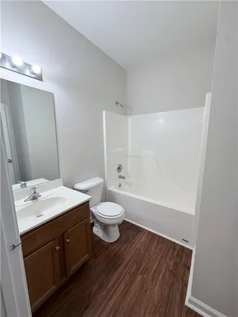a view of a livingroom with wooden floor and furniture