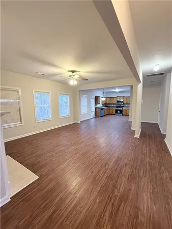a kitchen with granite countertop a stove top oven a sink dishwasher and a refrigerator with wooden floor