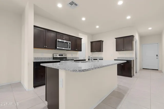 a kitchen with granite countertop a stove a sink and a microwave