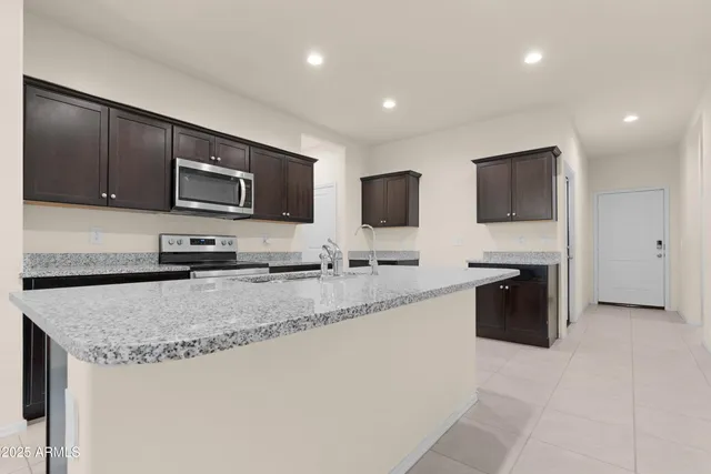 a kitchen with stainless steel appliances granite countertop a sink a stove and microwave