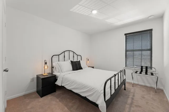 a bedroom with a bed and a large window