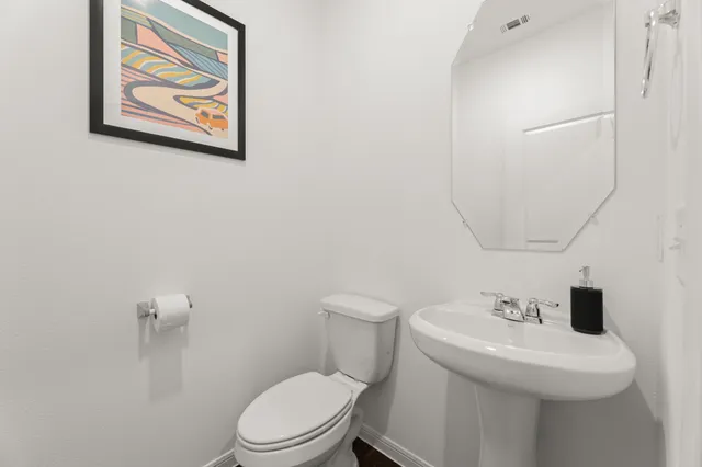 a bathroom with a toilet a sink and mirror