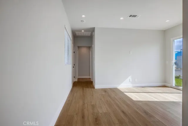 a view of a room with wooden floor and white walls