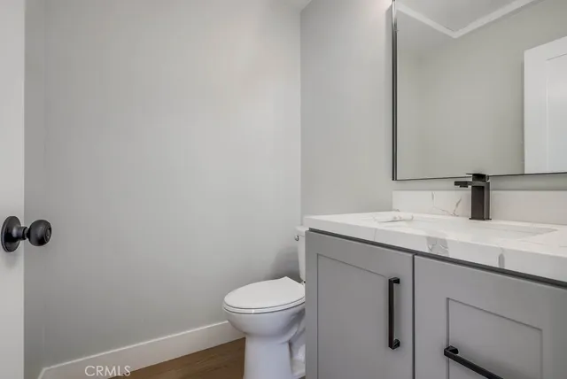 a bathroom with a granite countertop sink a toilet and a mirror