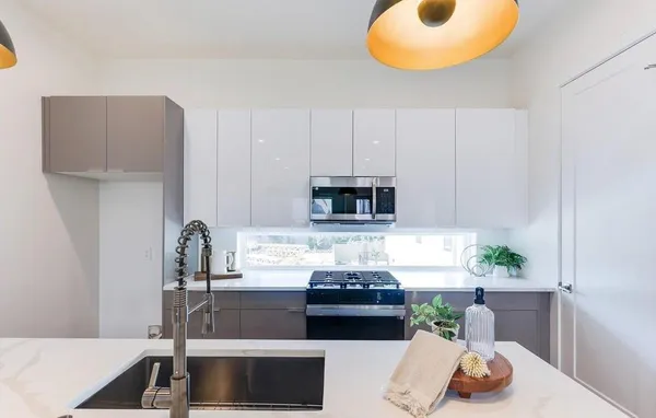 a kitchen with stainless steel appliances granite countertop a sink a stove and a refrigerator