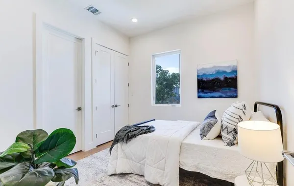 a bedroom with a bed and a painting on the wall