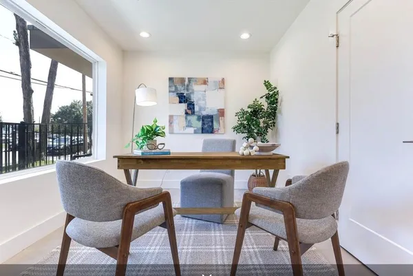 a view of a dining room with furniture wooden floor and a potted plant