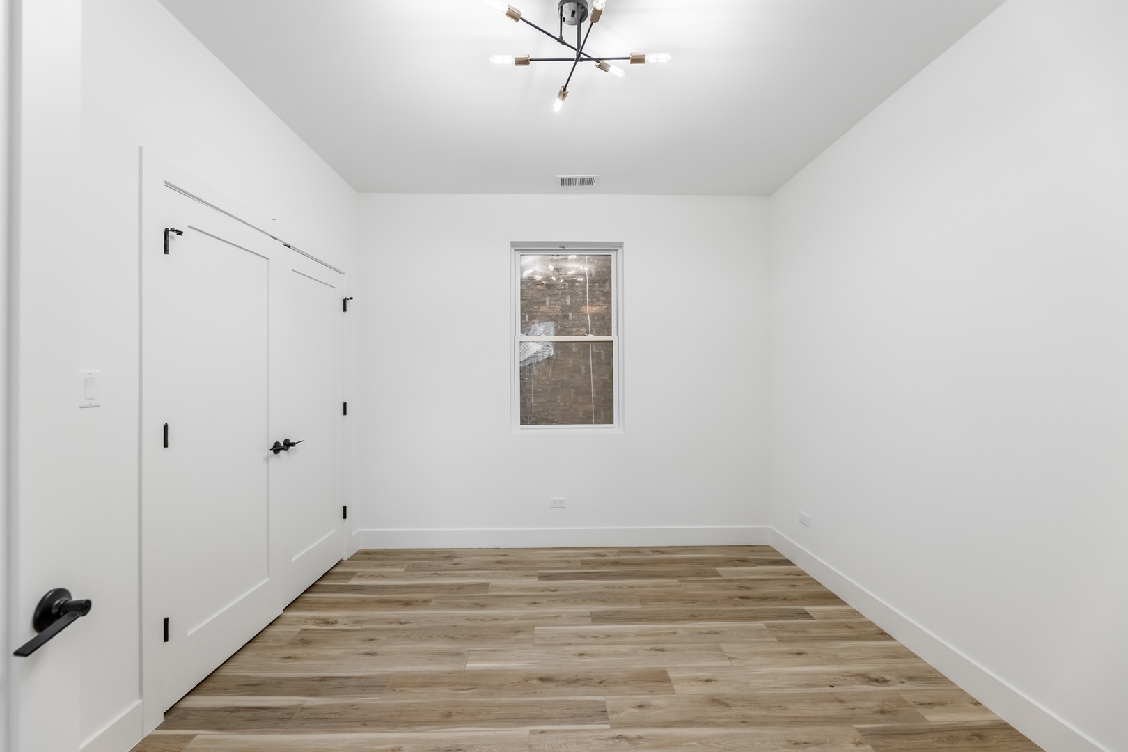 239 West 74th Street, Unit 1 Chicago, IL 60621 - Photo 3 of 5 a view of an empty room with wooden floor and a window