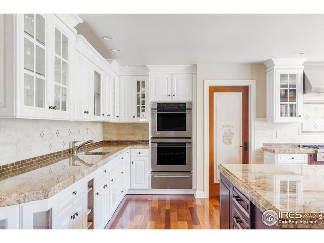 a kitchen with granite countertop a sink stove and cabinets