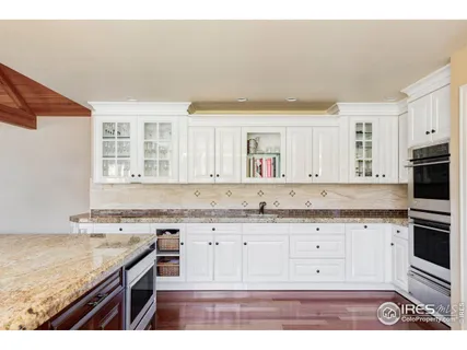 a kitchen with granite countertop a sink a stove and cabinets