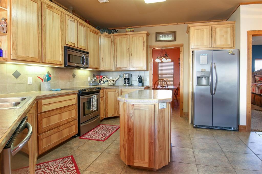 7158 Luella Road Sherman, TX 75090 - Photo 5 of 40 a kitchen with stainless steel appliances granite countertop a refrigerator a stove top oven and sink