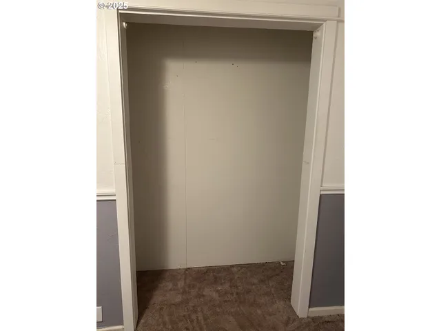 a view of a hallway with wooden floor and closet