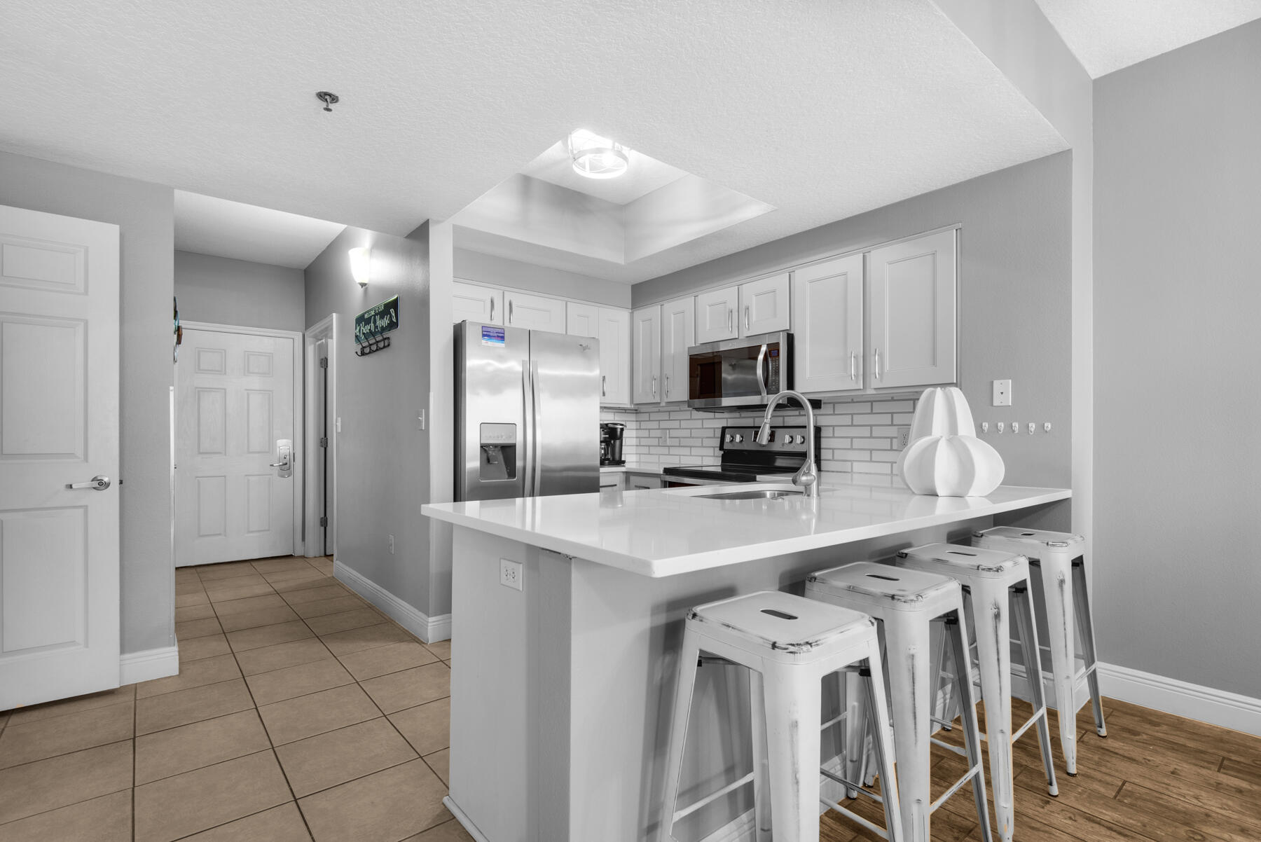 a kitchen with stainless steel appliances a sink a stove a refrigerator cabinets and a dining table