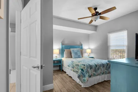 a bedroom with a large bed and a ceiling fan