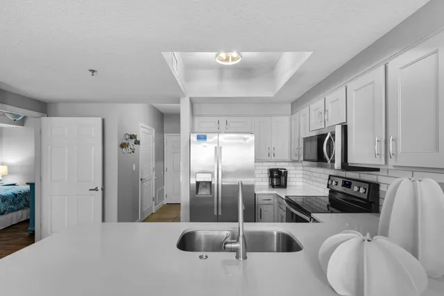 a kitchen with stainless steel appliances a refrigerator a sink a stove a microwave a counter top space and cabinets