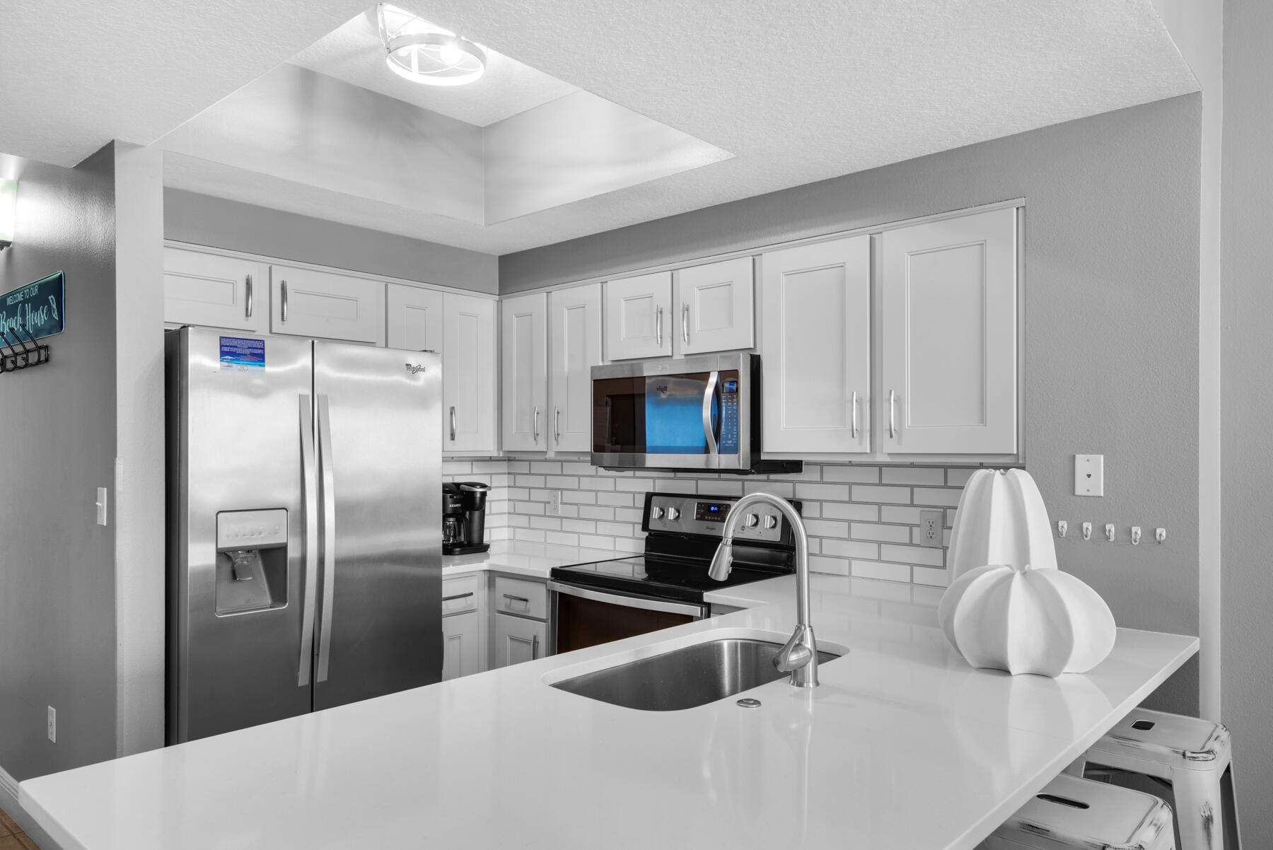 112 Seascape Drive, Unit 402 Miramar Beach, FL 32550 - Photo 6 of 31 a kitchen with granite countertop a refrigerator a sink a stove and white cabinets