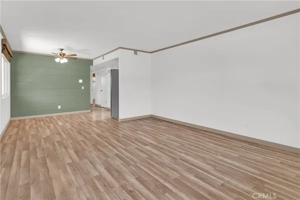 a view of a big room with wooden floor and windows