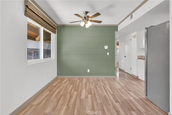 a view of a big room with wooden floor and a ceiling fan