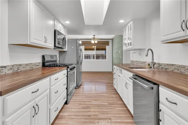 a large kitchen with granite countertop a sink and dishwasher a oven with wooden cabinets