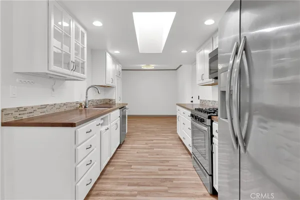 a kitchen with stainless steel appliances a sink stove and refrigerator