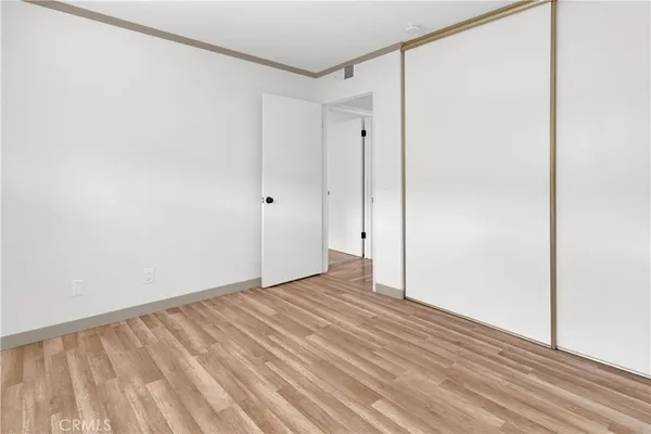 a view of an empty room with wooden floor