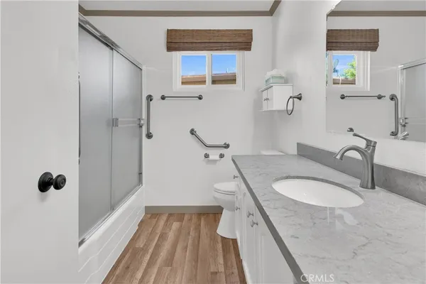 a bathroom with a granite countertop sink a mirror and shower
