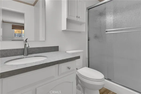 a bathroom with a granite countertop sink mirror vanity and toilet