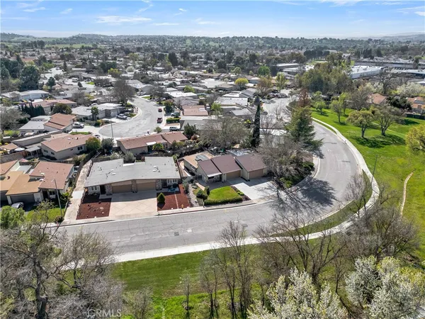 an aerial view of residential houses with outdoor space and parking
