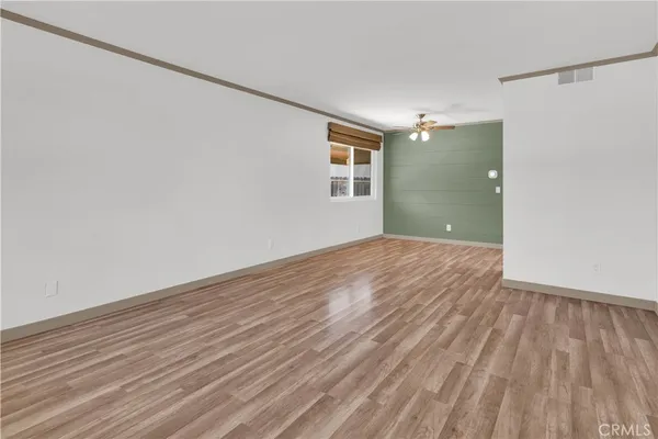 a view of a big room with wooden floor and windows