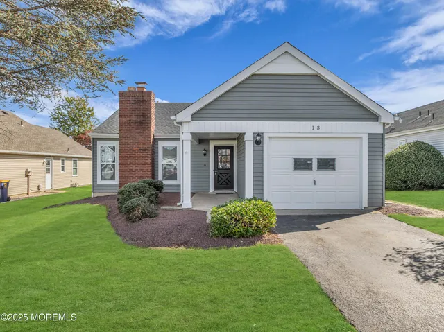 a view of a house with a yard and potted plants
