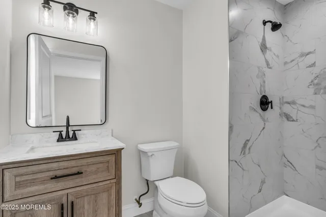 a bathroom with a toilet sink vanity and mirror