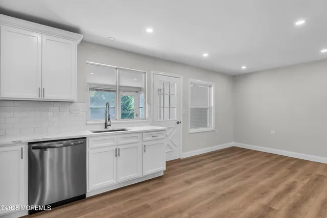 a large kitchen with granite countertop a sink and cabinets