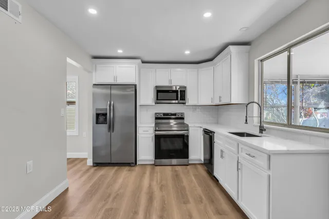 a kitchen with stainless steel appliances granite countertop a refrigerator and a sink