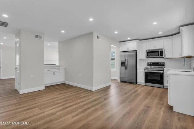 a view of kitchen with microwave and refrigerator