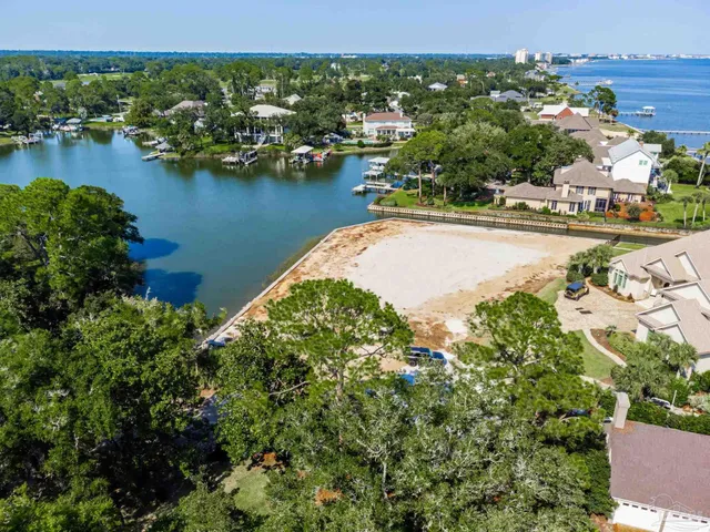 an aerial view of residential houses with outdoor space and lake view