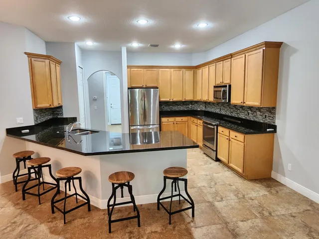 a view of a kitchen with granite countertop a sink and a window