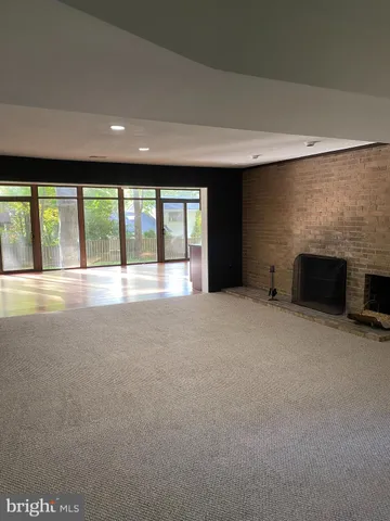 a view of an empty room with a fireplace and a large window