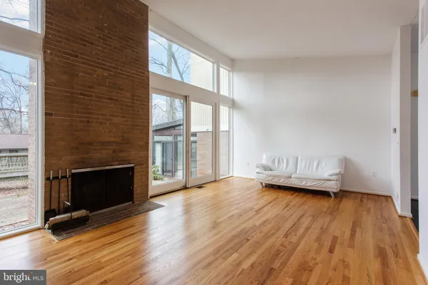 a view of a livingroom with wooden floor and a fireplace